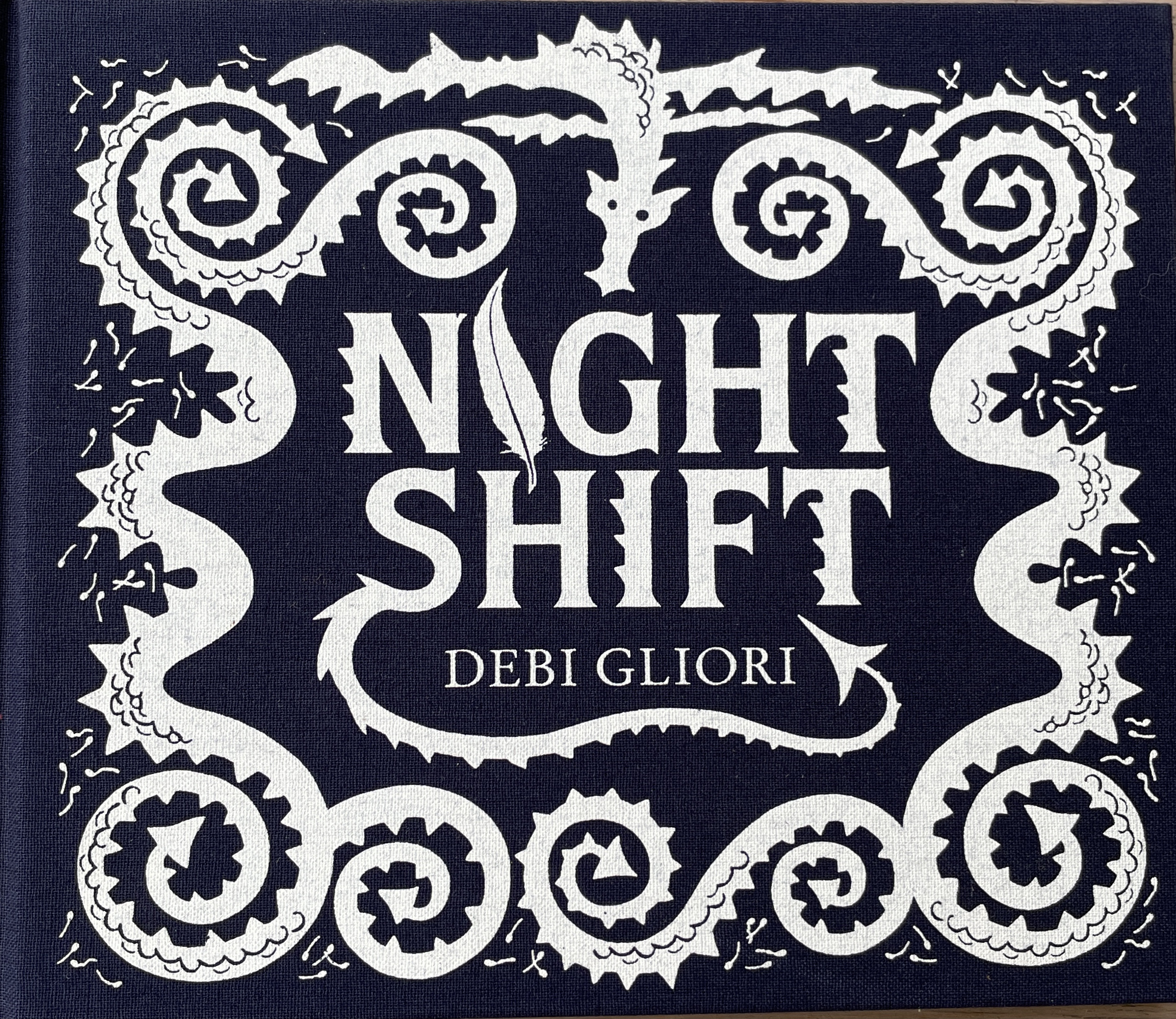 Two colour book cover with decorative border of dragon and curly dragon tails